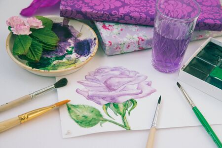 watercolor sketch of a purple rose with brushes and paintsの写真素材