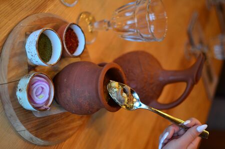 clay pot and spoon, stew (meat in the pot)