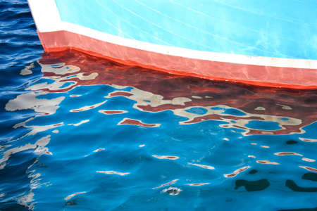 Colorful wooden boat bow and its reflection in the seaの写真素材