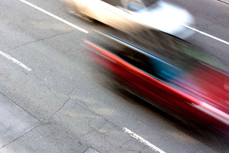 Two cars speeding on the street in motion blur