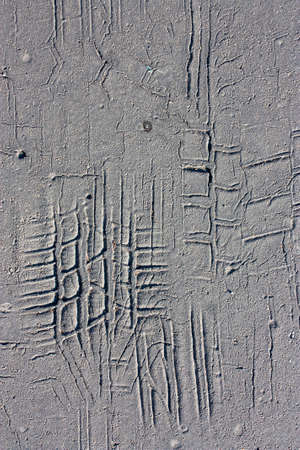 Tire imprints on old cracked asphalt road in blak and white