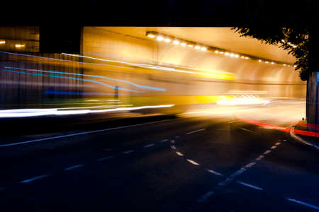 Night traffic on city streets. Vehicles getting in and out of the tunnelの写真素材