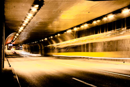 Night traffic on city streets. Vehicles getting in and out of the tunnel in motion blur