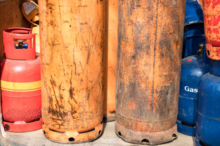Different color and size cylinder gas bottles stored for refill and supply