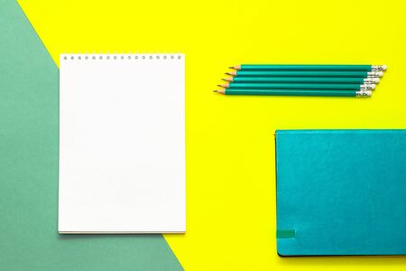 White wideopen blank clean notepad page and green pencils on yellow-green table.の写真素材