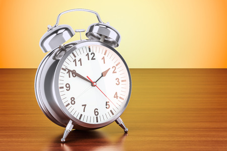 Steel alarm clock on the wooden table. 3D rendering 