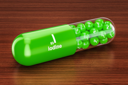 Capsule with iodine I element on the wooden table. 3D renderingの写真素材