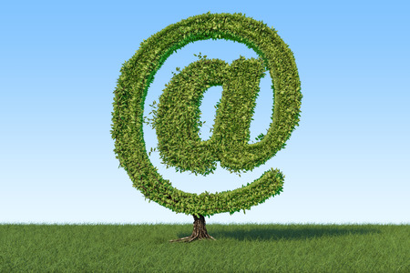 Tree in the shape of mail symbol on the green grass against blue sky, 3D rendering の写真素材