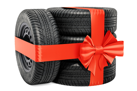 Car wheels wrapped ribbon and bow, gift concept. 3D rendering isolated on white backgroundの写真素材