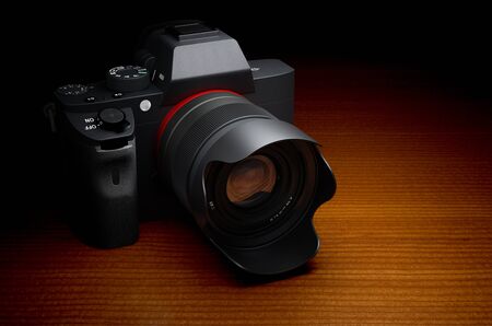 Mirrorless interchangeable-lens camera. Digital camera on wooden table, 3D rendering