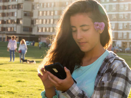 Girl with mobile phone in hands looking at himの写真素材