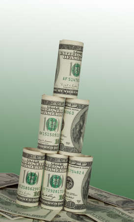 Leaning Tower of hundred dollar bills on green backgroundの写真素材