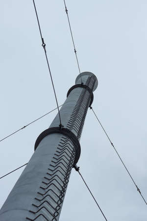 Industrial metal pipe with a ladder against the skyの写真素材
