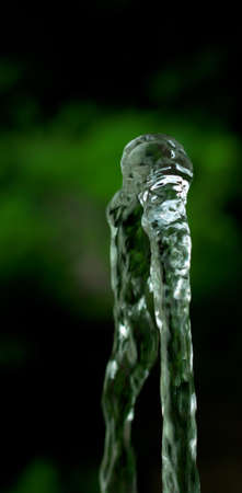 Trickle of water from the fountain in the sunの写真素材