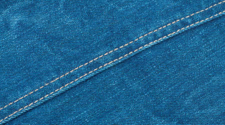 Denim background with a diagonal seam through itの写真素材