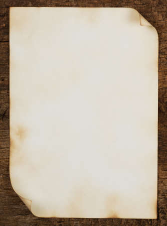 Grunge background with a burned piece of paper on the boardの写真素材