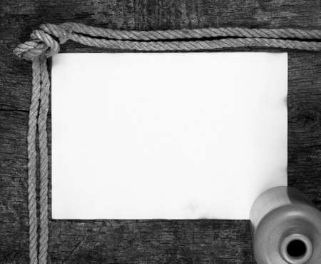 Sheet of old paper with a bottle on a wooden backgroundの写真素材