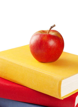 Red apple on a pile of books isolated on white backgroundの写真素材