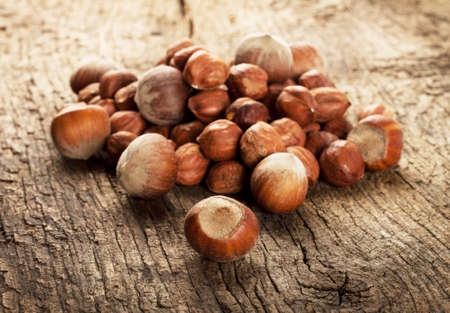 Pile of ripe hazelnuts on wooden backgroundの写真素材