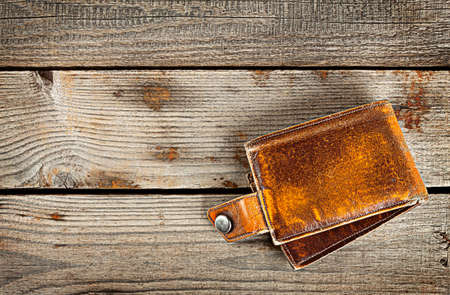 Yellow leather wallet on a wooden background
