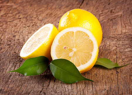 Ripe bright lemons on a wooden backgroundの写真素材