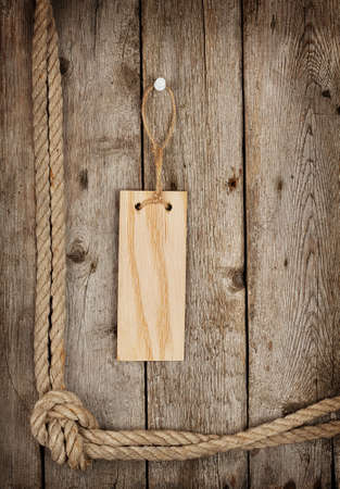 Wooden sign on the wooden background with ropeの写真素材