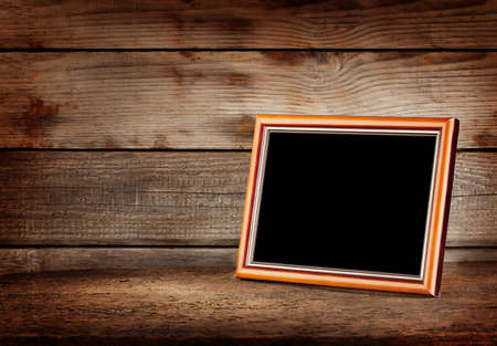 Empty wooden picture frame on a wooden tableの写真素材