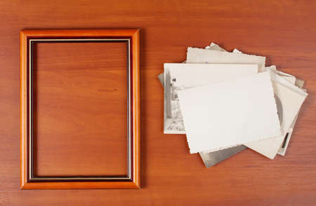 Wooden photo frame with old photos on wooden background