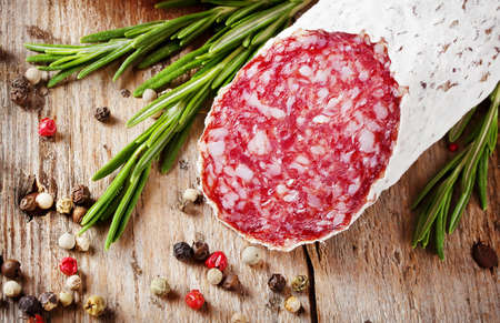 Stick fresh salami with pepper and rosemary