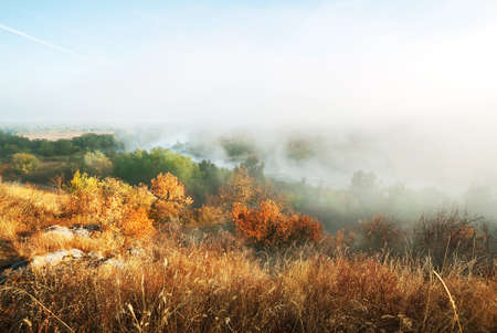 Foggy morning on the mountain river under the blue skyの写真素材