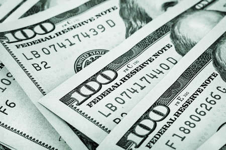 Background of the folded fan of hundred-dollar bills stained in green toneの写真素材