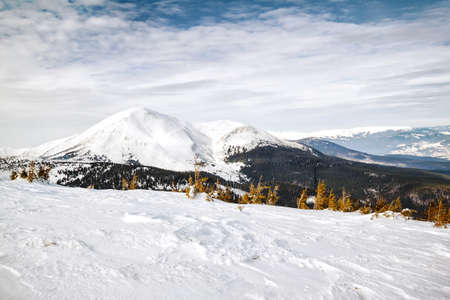 Snow-capped mountains under blue cloudy skyの写真素材