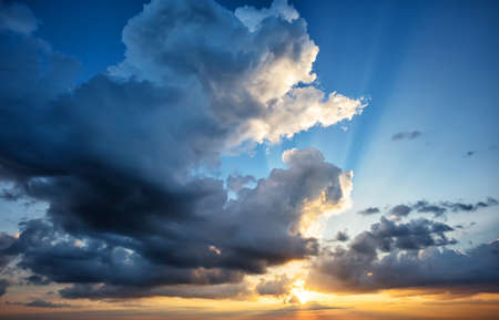 Dramatic sky with a setting sun and orange clouds