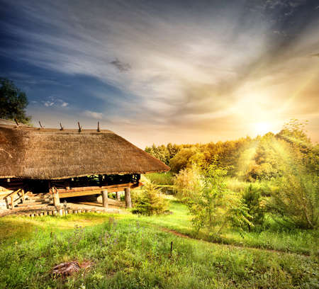 Wooden pergola with a thatched roof at sunset skyの写真素材