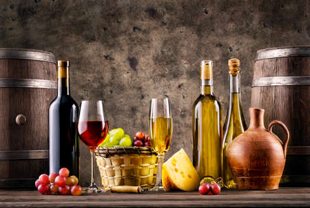 Still life with wine, grapes, barrels and cheese on grunge backgroundの写真素材