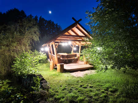 Fairy gazebo in woods lit lanterns at nightの写真素材