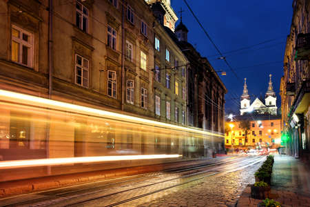Street with tracks headlights at nightの写真素材