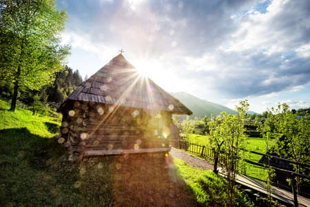 Wooden house in middle of lawn at sunset in mountains Carpathiansの写真素材