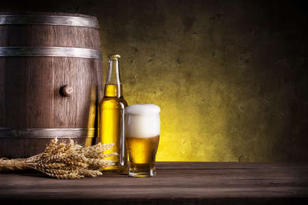 Barrel, bottle and glass of beer on a yellow backgroundの写真素材
