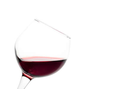 Slanted glass of red wine isolated on white backgroundの写真素材