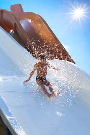The child goes down the water slideの写真素材
