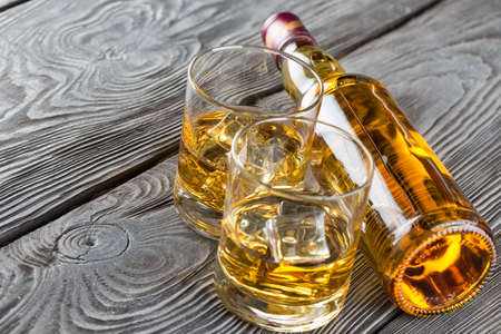 Bottle and glass of whiskey on a wooden backgroundの写真素材