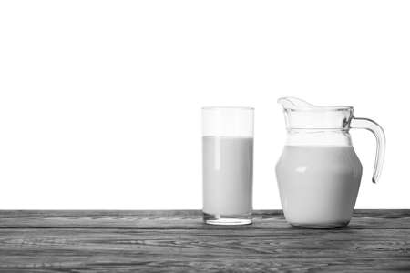 Jug and glass of milk on a wooden tableの写真素材
