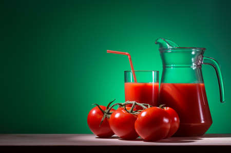 Glass and decanter of tomato juice with tomatoesの写真素材