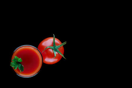 Glass of tomato juice with parsley and a tomatoの写真素材