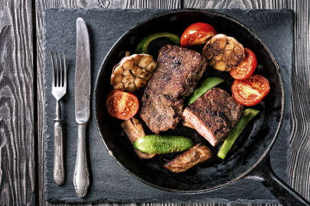 Frying pan with steak and baked vegetables on the table. Toning. The concept of healthy eating.の写真素材