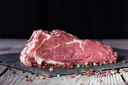 A piece of fresh steamed meat for steak on a table with pepper. Concept of cooking and healthy eating.の写真素材