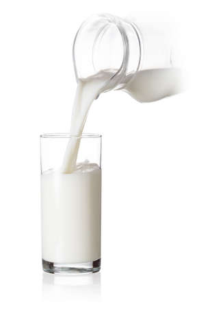 Glass filled with milk pouring from a jug. Isolate on white. The concept of natural drinks.の写真素材