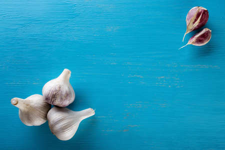 Three heads and cloves of garlic on a wooden table. Spice. Food background. The concept of healthy food.の写真素材