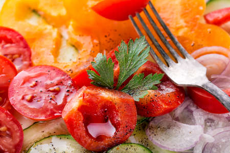 Fragment of fresh vegetable salad with a forkの写真素材